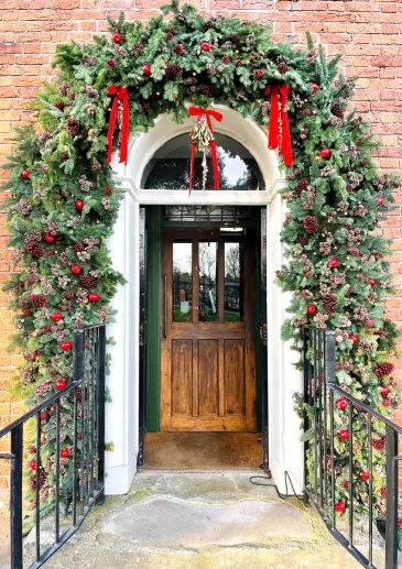 Fresh Christmas Greenery, bows and red decorations by Booker Flowers Liverpool Christmas Decorators. Commercial Festive Decorating Services